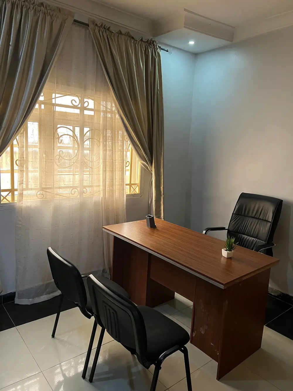 A consultation room at Rahama Wellness Center in Abuja, with a desk, a clinician's chair and two chairs for visitors.
